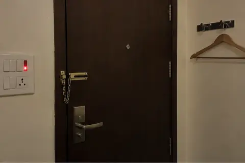 A hotel room door from inside with the chain on